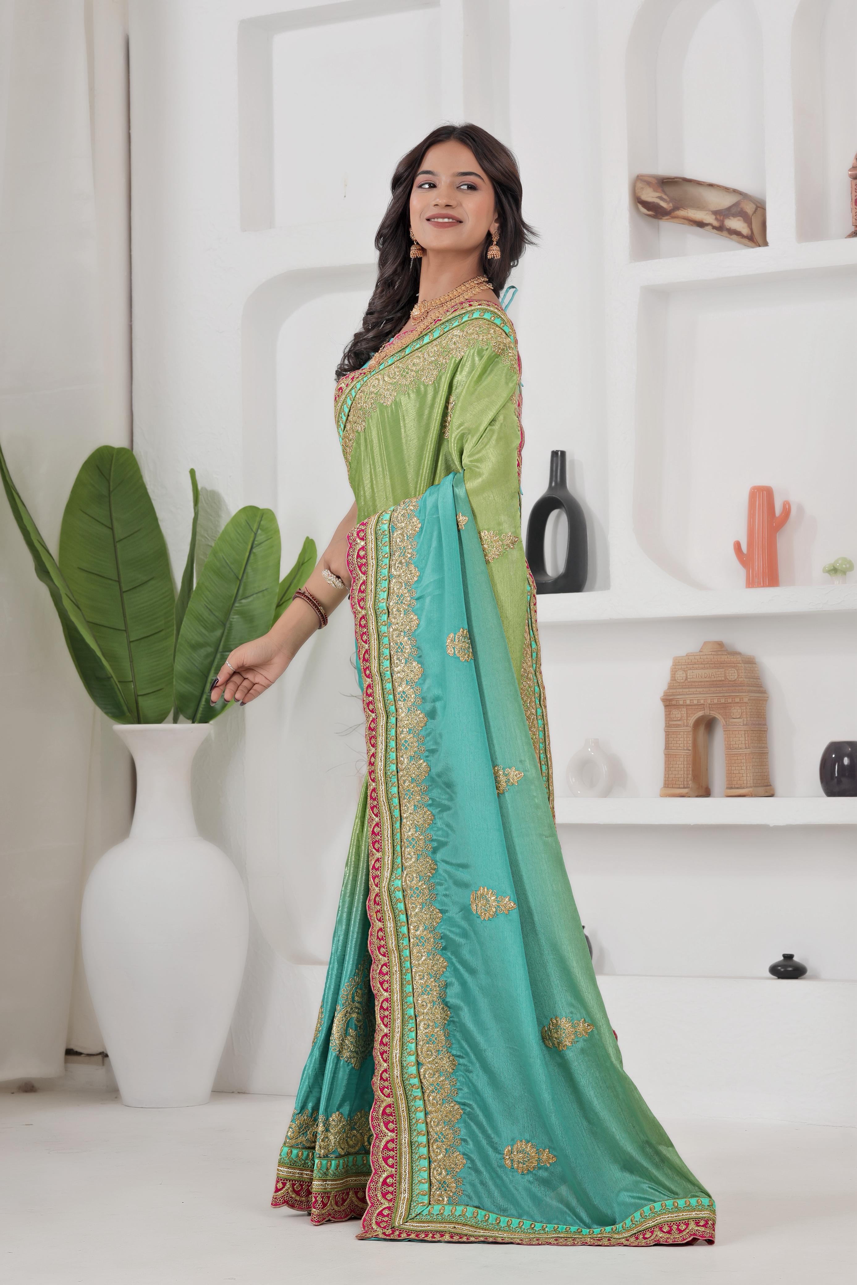 Woman wearing a green and blue saree with a white background