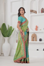 Woman wearing a green and blue saree with a white background