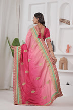Woman wearing a pink saree with gold and green border indoors.