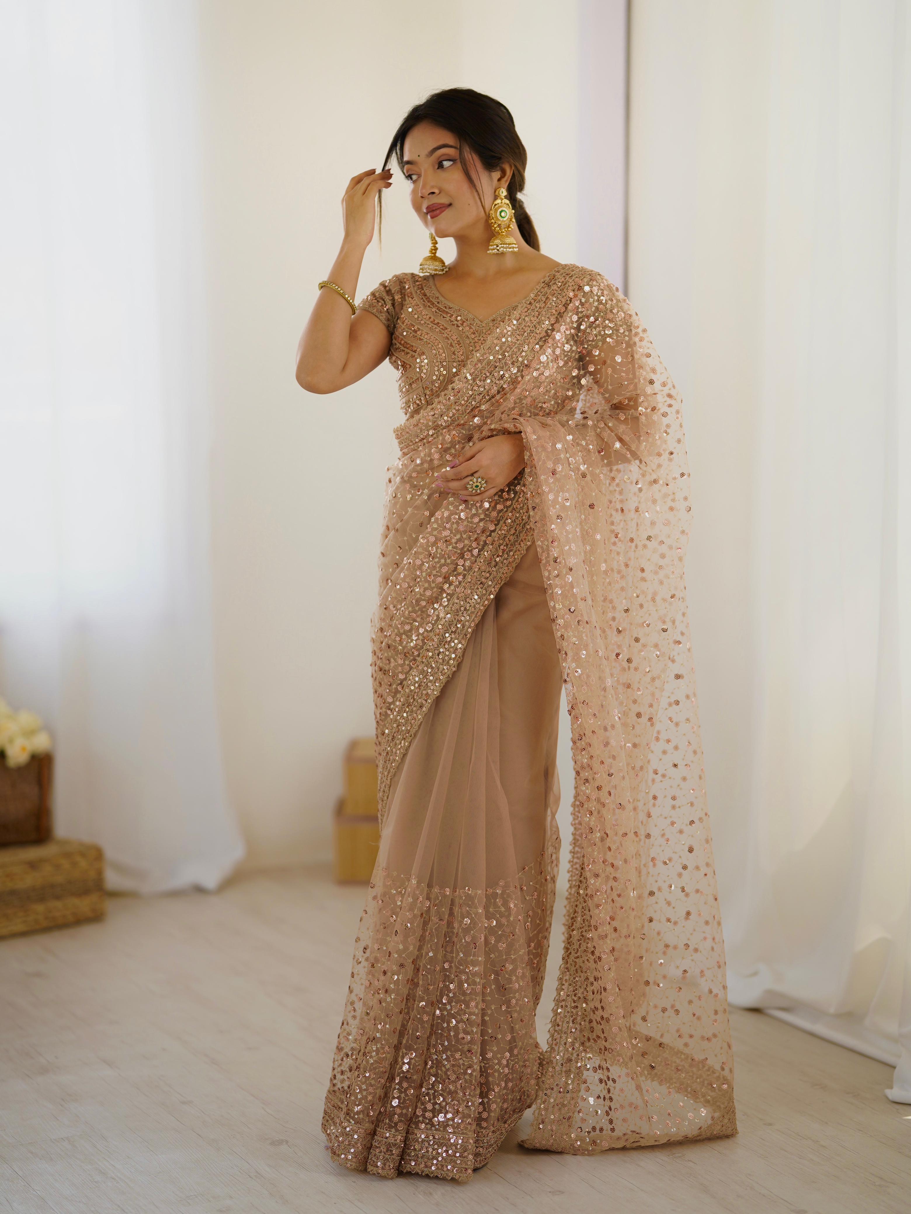 Woman wearing a beige sequin saree in a minimal indoor setting