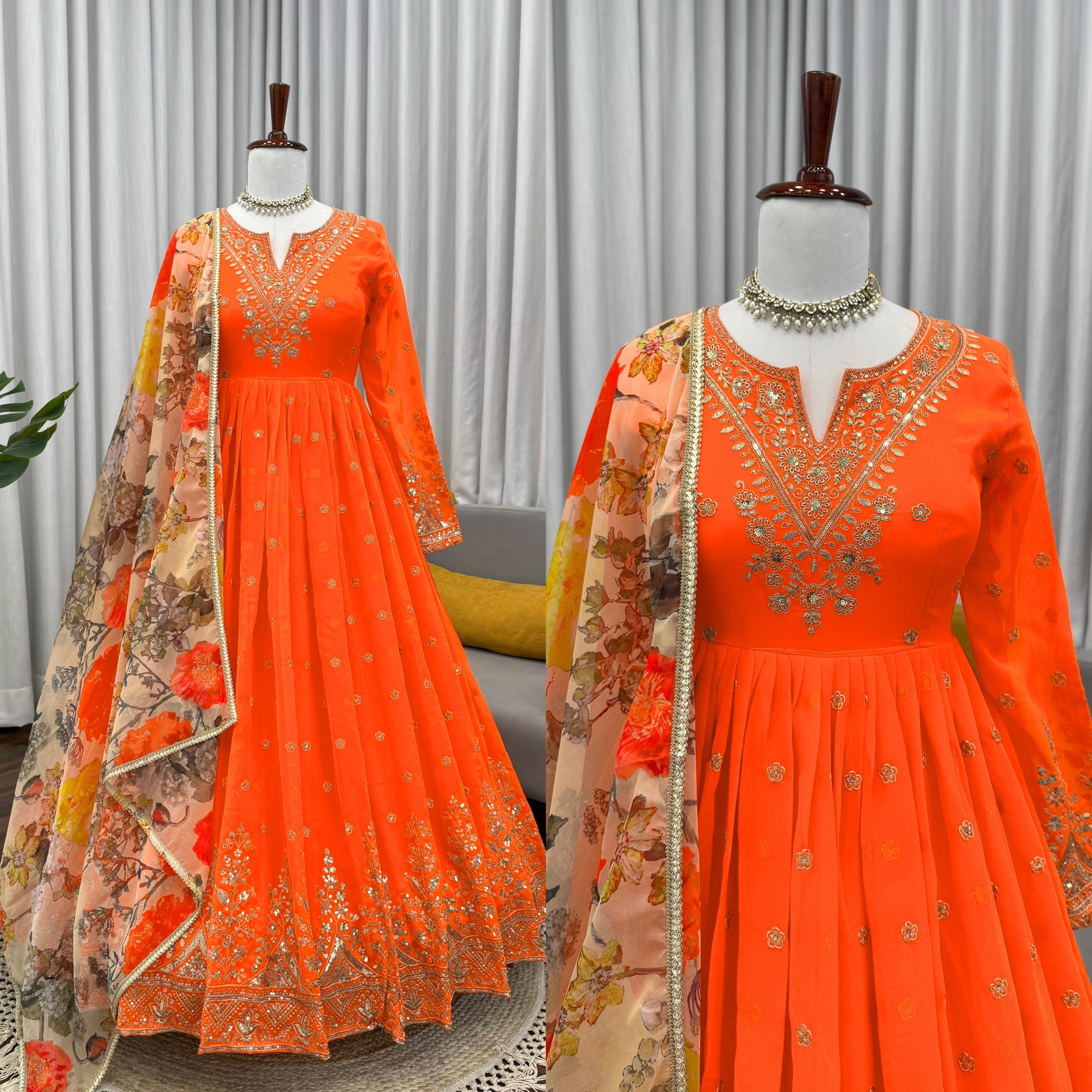 Orange embroidered dress with floral dupatta on mannequins against a neutral background