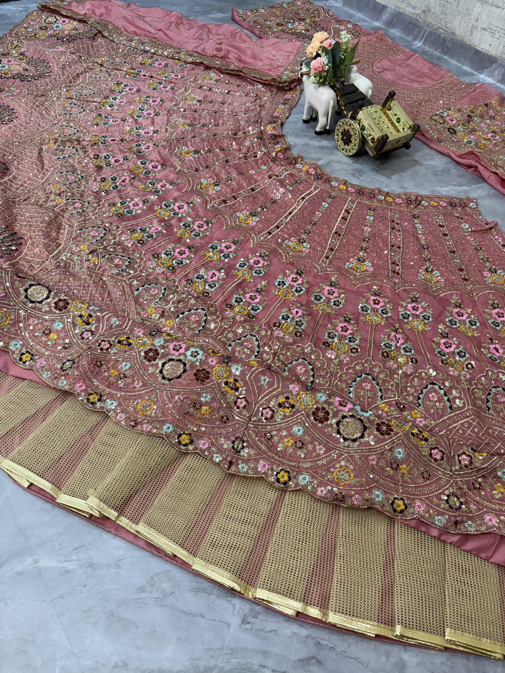 Pink embroidered lehenag with a decorative border and can can.