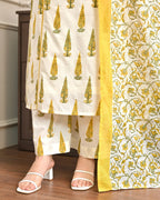Traditional outfit with white pants and yellow floral dupatta on a wooden floor.