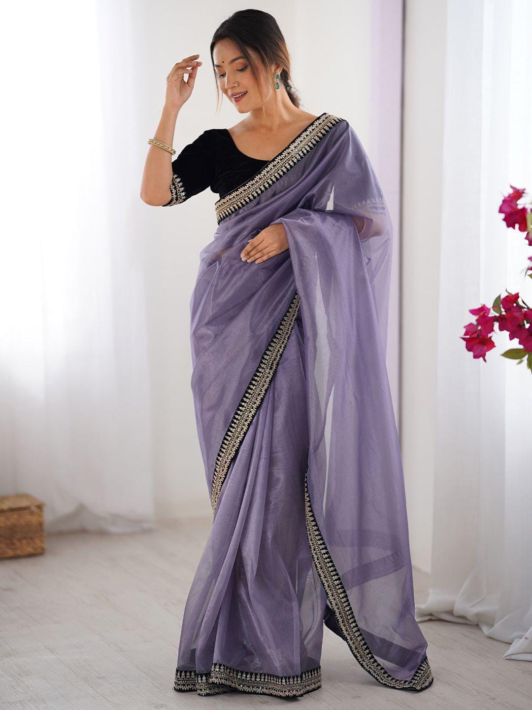 Woman wearing a lavender saree with a white background