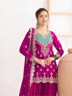 Woman wearing a vibrant purple embroidered traditional outfit with a white background