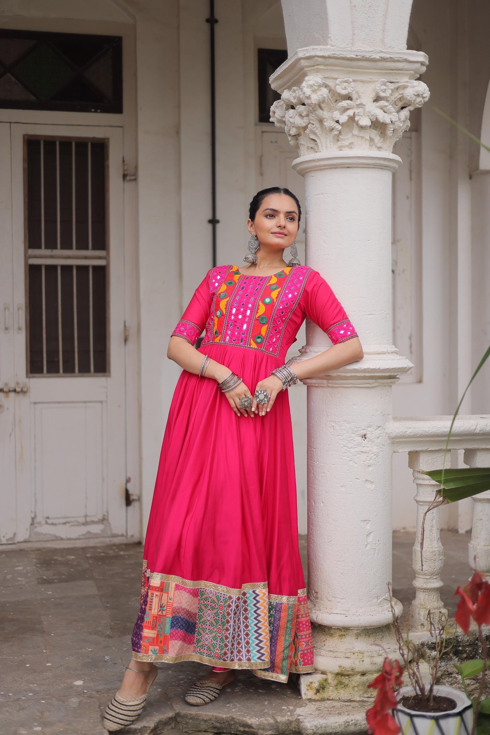 Pink festive gown with mirror work and ethnic border design
