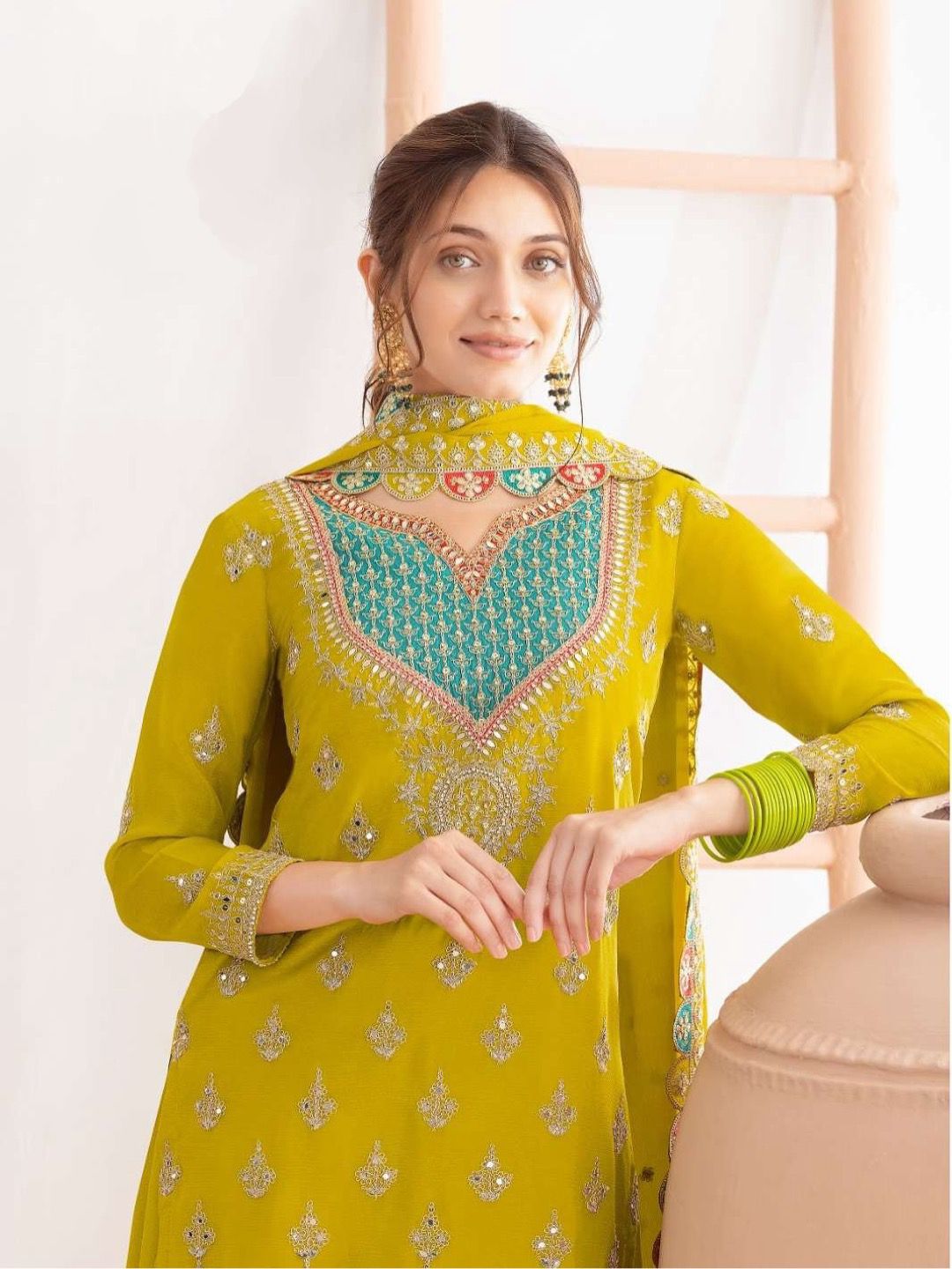 Woman wearing a yellow and green embroidered traditional outfit.